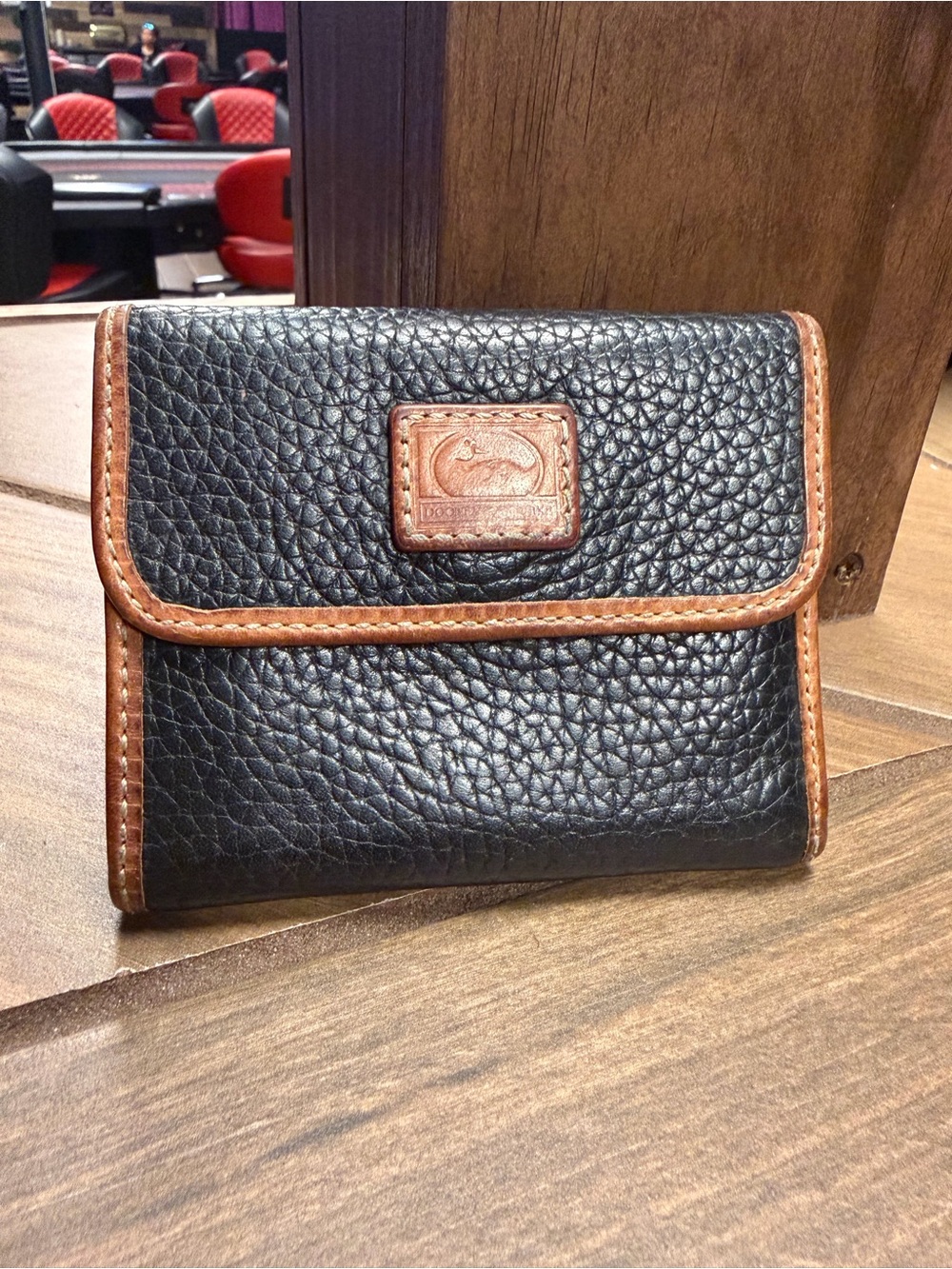 Dooney & Bourke Black Pebbled Leather Wallet with Brown Trim and Logo Patch